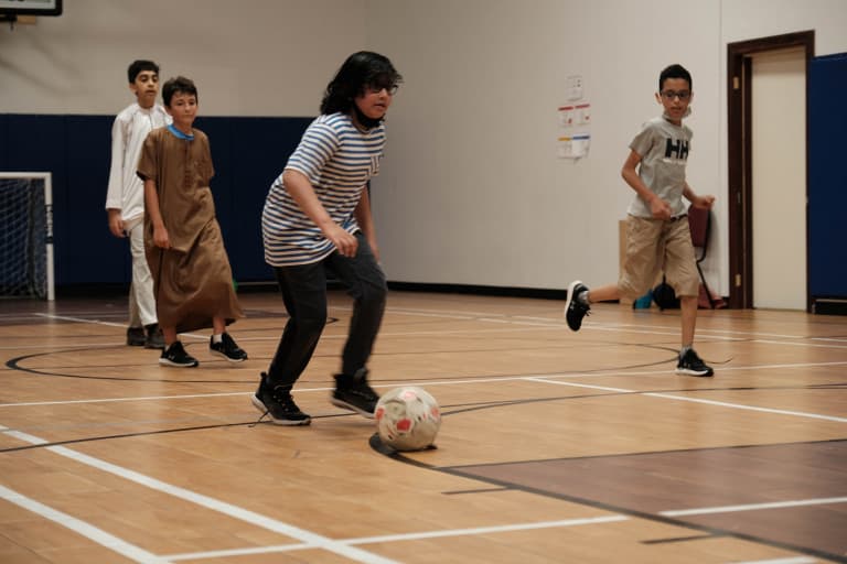 Students playing indoor soccer in the gym