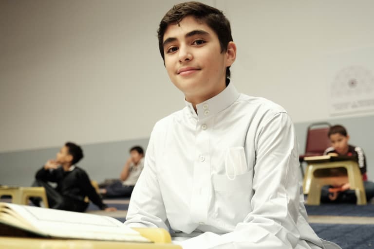 Student with an open Quran at Abu Huraira Center